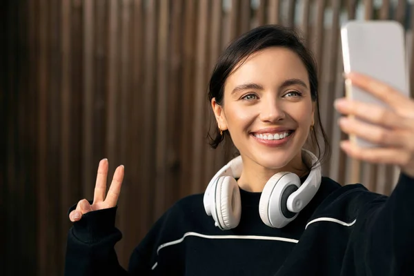 Happy Young European Woman Athlete Sportswear Headphones Makes Peace Sign — Stock Photo, Image