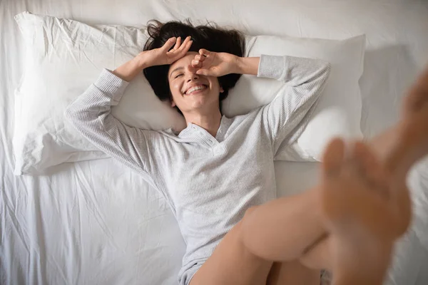 Laughing Young European Woman Wakes Raises Legs Has Fun Alone — Stok fotoğraf