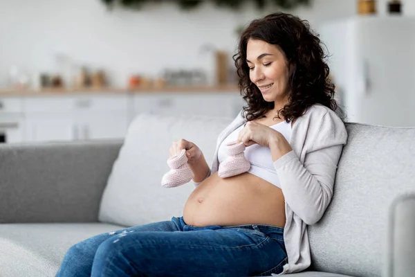 Beautiful Young Pregnant Woman Placing Small Baby Shoes Her Belly — Fotografia de Stock