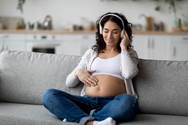 Beautiful Pregnant Woman Listening Music Wireless Headphones While Relaxing Couch — 图库照片
