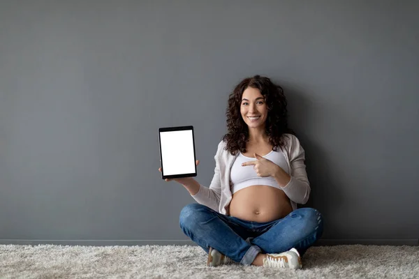 Beautiful Pregnant Woman Pointing Digital Tablet Blank Screen While Sitting — Foto Stock