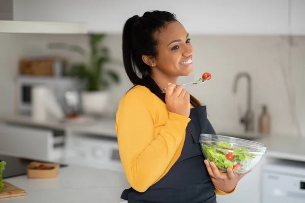 Cheerful Pretty Millennial African American Lady Apron Eat Fresh Vegetable — Stockfoto