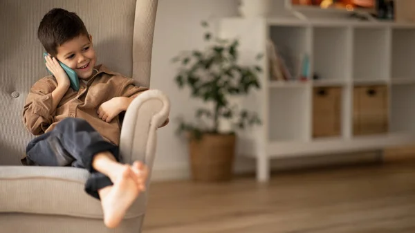 Smiling Small European Boy Sit Armchair Calling Phone Talking Parents — Stock fotografie
