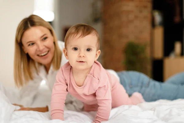 Happy Mother Lying Baby Toddler Bed While Kid Girl Crawling — Stock Photo, Image
