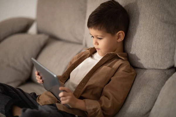 Serious Small European Boy Sitting Sofa Watch Video Playing Game —  Fotos de Stock