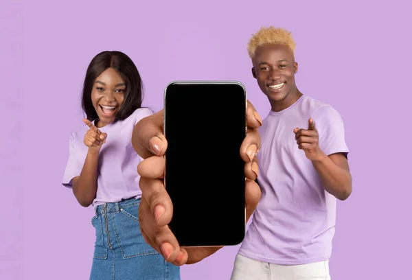Cheerful Black Couple Holding Blank Smartphone Pointing Camera Fingers Positive — Stockfoto