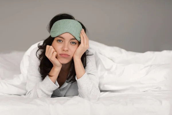 Sad Tired Young European Woman Sleep Mask Lies White Comfortable — Zdjęcie stockowe