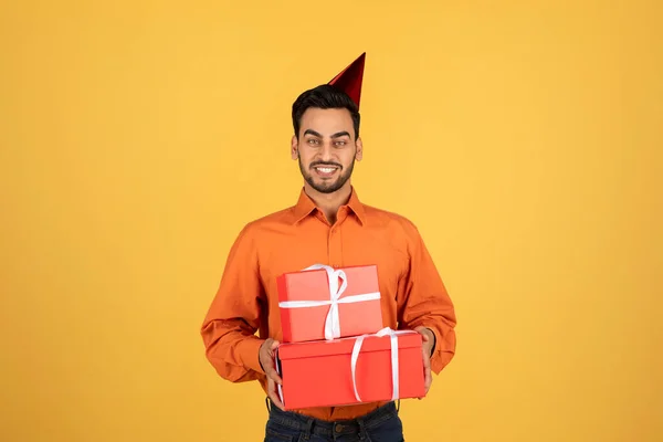 Handsome Arab Man Holding Wrapped Gift Boxes Wearing Birthday Hat — Stock Photo, Image