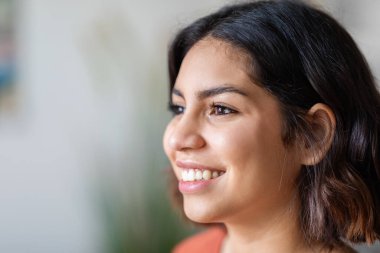 Portrait Of Cheerful Young Beautiful Arab Woman Smiling And Looking Away, Closeup Shot Of Happy Millennial Attractive Middle Eastern Female Face With Flawless Skin And No Makeup, Copy Space