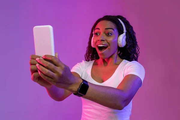 Cool App Surprised Black Woman Wearing Wireless Headphones Looking Smartphone — Photo