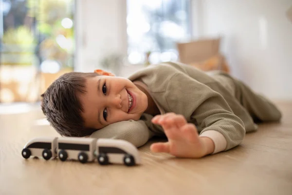 Smiling Pensive Small European Boy Pajamas Lies Floor Enjoy Relax — стоковое фото