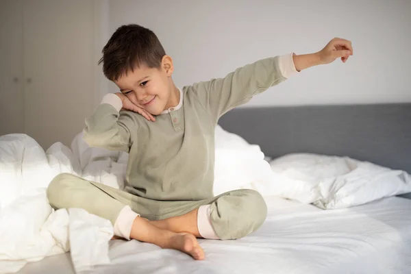 Happy Pretty Small European Boy Pajamas Wake Stretching Body Enjoys — стоковое фото