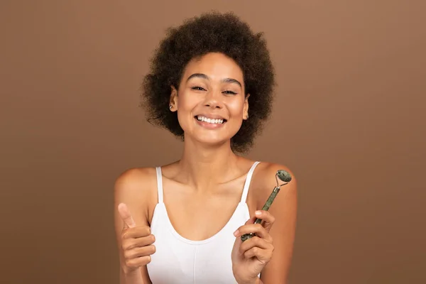 Cheerful Millennial Multiethnic Woman Show Thumb Jade Roller Isolated Brown — Stockfoto