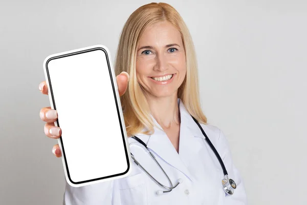 Gülümseyen Doktor Üniformalı Kadın Büyük Akıllı Telefonu Kamerada Gösteriyor Neşeli — Stok fotoğraf