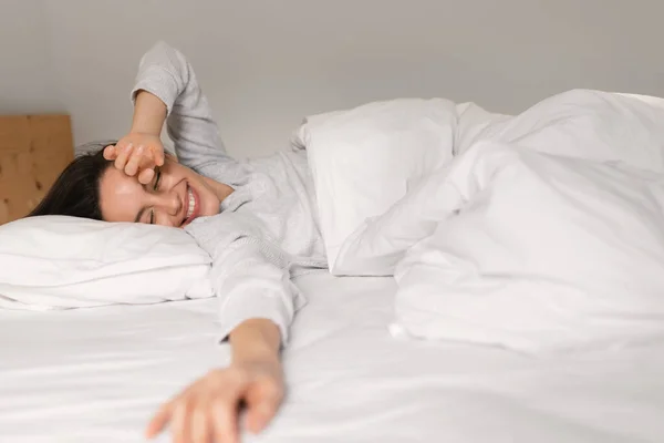 Cheerful Caucasian Millennial Female Sleeping Comfortable Bed Enjoying Softness Weekend — Zdjęcie stockowe
