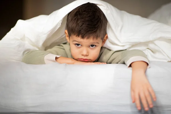 Tired Sad Caucasian Little Child Lies Bed Blanket Looks Camera — Stock Photo, Image