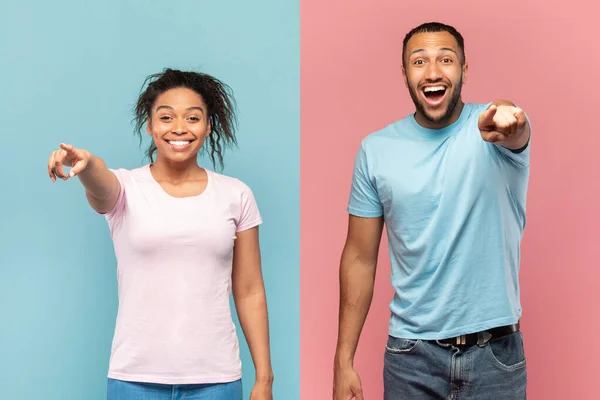 Hey, you. Joyful black couple pointing at camera, excited man and woman indicating somebody and having fun together while standing over pink and blue background