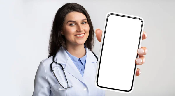 Medische Diensten Glimlachende Vrouwelijke Arts Houdt Smartphone Met Blanco Scherm — Stockfoto