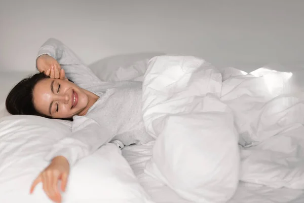 Glad Young European Lady Sleeping White Bed Closed Eyes Waking — Zdjęcie stockowe