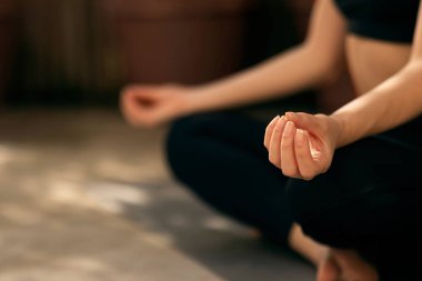 Caucasian millennial lady in sportswear practicing yoga, meditates on street, enjoy peace and calm at free time, focus on hands, cropped, close up. Sports and body care, workout and active in city