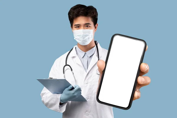 Реклама Здравоохранение Молодой Азиатский Врач Медицинской Маске Показывает Холостой Смартфон — стоковое фото