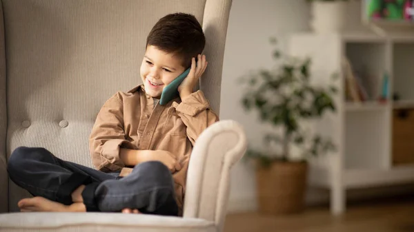 Glad Caucasian Little Kid Casual Calls Phone Talk Sits Armchair — Stock Photo, Image