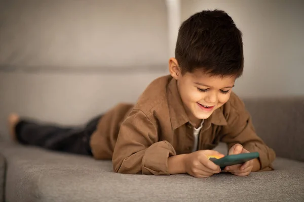 Glad Caucasian Little Child Casual Watching Video Smartphone Lies Sofa — Stock Photo, Image
