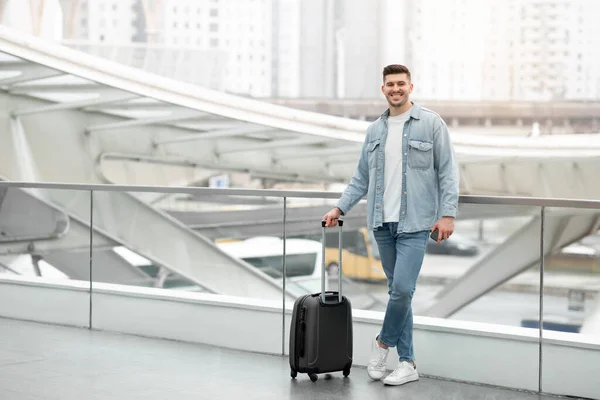 Cheerful Tourist Guy Standing Travel Suitcase Smiling Camera Posing Airport — Foto Stock