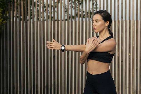 Serious Caucasian Millennial Muscular Slim Female Sportswear Doing Arm Stretching — Stok fotoğraf