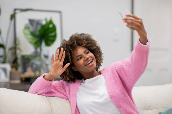 Attractive Cheerful Happy Millennial Black Woman Bushy Hair Sitting Couch – stockfoto