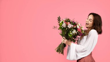Happy inspired surprised young european woman enjoy bouquet of white tulips, rejoice spring holiday isolated on pink background, panorama, studio. Gift at date, birthday, congratulation, ad and offer