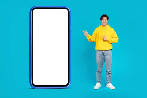Happy Asian Teen Boy Pointing Fingers Big Phone Empty Screen — 스톡 사진