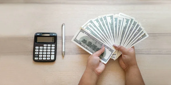 Mãos Femininas Segurando Monte Dólares Dinheiro Caneta Calculadora Mesa Madeira — Fotografia de Stock