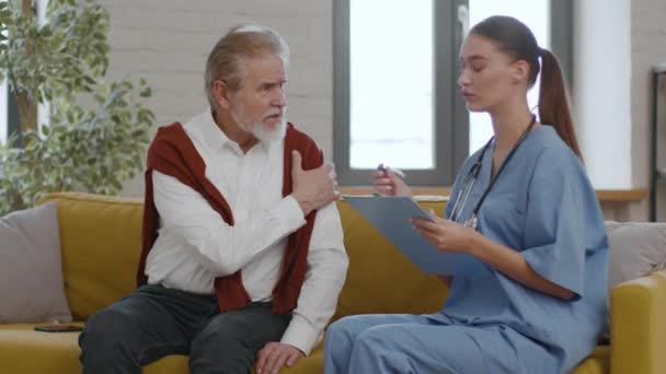 Åldrande Och Hälsoproblem Ung Professionell Kvinna Sjuksköterska Frågar Senior Man — Stockvideo