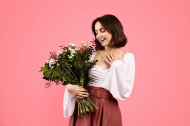 Its for me. Glad surprised young european woman enjoy gift, bouquet of white tulips, rejoice spring holiday, isolated on pink background, studio. Congratulation at women day, birthday, ad and offer