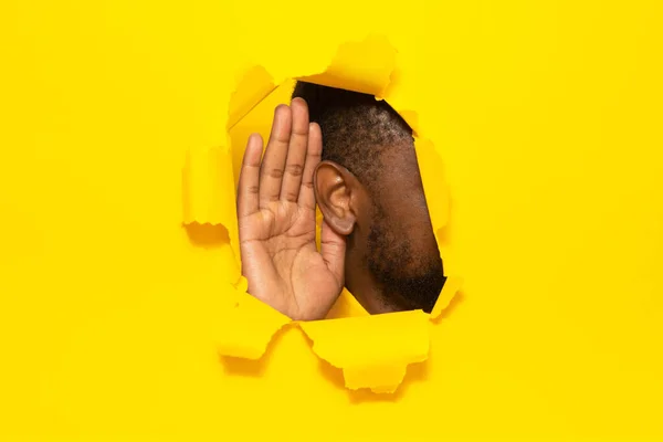 Eavesdropping Unrecognizable Black Guy Putting Ear Torn Yellow Paper Background — Stock Photo, Image