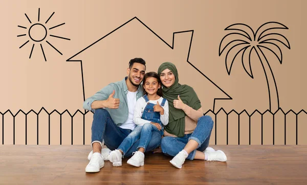 Portrait of smiling muslim people sitting on the floor over house doodles. Cheerful man, woman in hijab and little girl showing thumb up sign gesture and smiling, moving to new house, collage