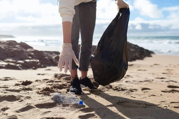 年轻女子从海滩收集塑料垃圾 并将其放入塑料袋中循环利用 近距离拍摄 清洁和循环利用 拯救地球的概念 — 图库照片
