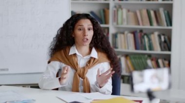 Profesyonel eğitim. Ofisteki iş blogunda genç bir kadın uzman kayıt yapıyor. Belgeleri ve mali raporları nasıl dolduracağını anlatıyor. Akıllı telefondan çekimler, izleme çekimleri, boş alan.