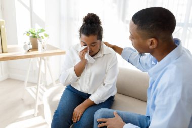 Professional psychological help concept. African american handsome young man psychologist supporting crying hispanic millennial overweight woman during therapy session, copy space