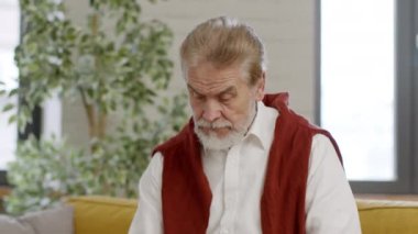 Herhangi bir yere taşınabilir bağlantı. Pozitif kıdemli sakallı adam cep telefonuna bakıyor ve cevaplıyor, mutlu bir şekilde selamlıyor, takip ediyor, yavaş çekim, serbest alan