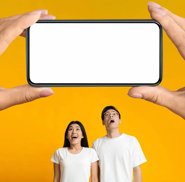 Amazed Asian Couple Looking Big Smartphone White Screen Huge Hands — Fotografia de Stock