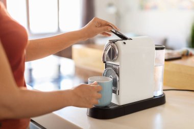 Young Woman Using Coffee Machine While Making Cup Of Coffee At Home, Unrecognizable Female Preparing Caffeine Drink With Modern Appliance In Kitchen, Enjoying Start Of The Day, Cropped Image