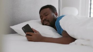 Night symptoms of sickness. Close up portrait of sleeping african american guy waking up and coughing, keep resting in his bed, tracking shot, slow motion, free space