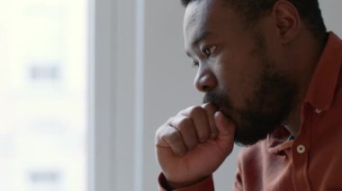 Personal crisis. Side view portrait of young depressed african american man contemplating about his life, feeling depressed at home, close up, slow motion, empty space