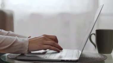 Uzaktan çalışma konsepti. Dizüstü bilgisayarda yazı yazan kadınların yan görüntüsü, evde çalışan tanınmayan bir kadın, yavaş çekim, boş alan