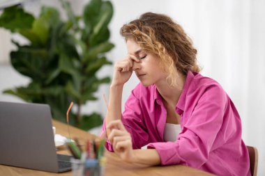 Tired Female Freelancer Feeling Eyes Strain After Working Remotely With Laptop At Home Office, Exhausted Young Woman Sitting At Desk With Computer And Massaging Nose Bridge, Closeup Portrait