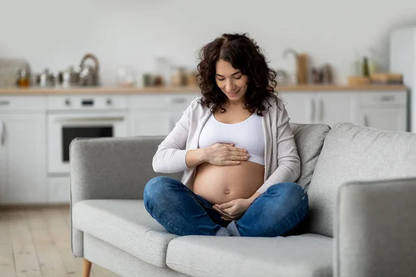 Motherhood Concept Happy Pregnant Woman Tenderly Embracing Belly While Sitting — Stockfoto