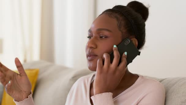 顧客の助けを求める若いイライラしたアフリカ系アメリカ人女性の依頼人悪いサービスのために助けを求めて家に座って撮影を追跡スローモーションフリースペース — ストック動画