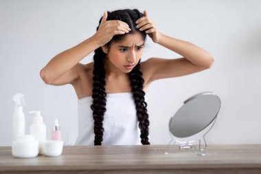 Dandruff Problem. Upset Young Indian Woman Looking To Mirror At Her Hair Roots, Shocked Hindu Female Suffering Dry Flaky Scalp After Bath, Having Problems With Haircare Routine, Copy Space